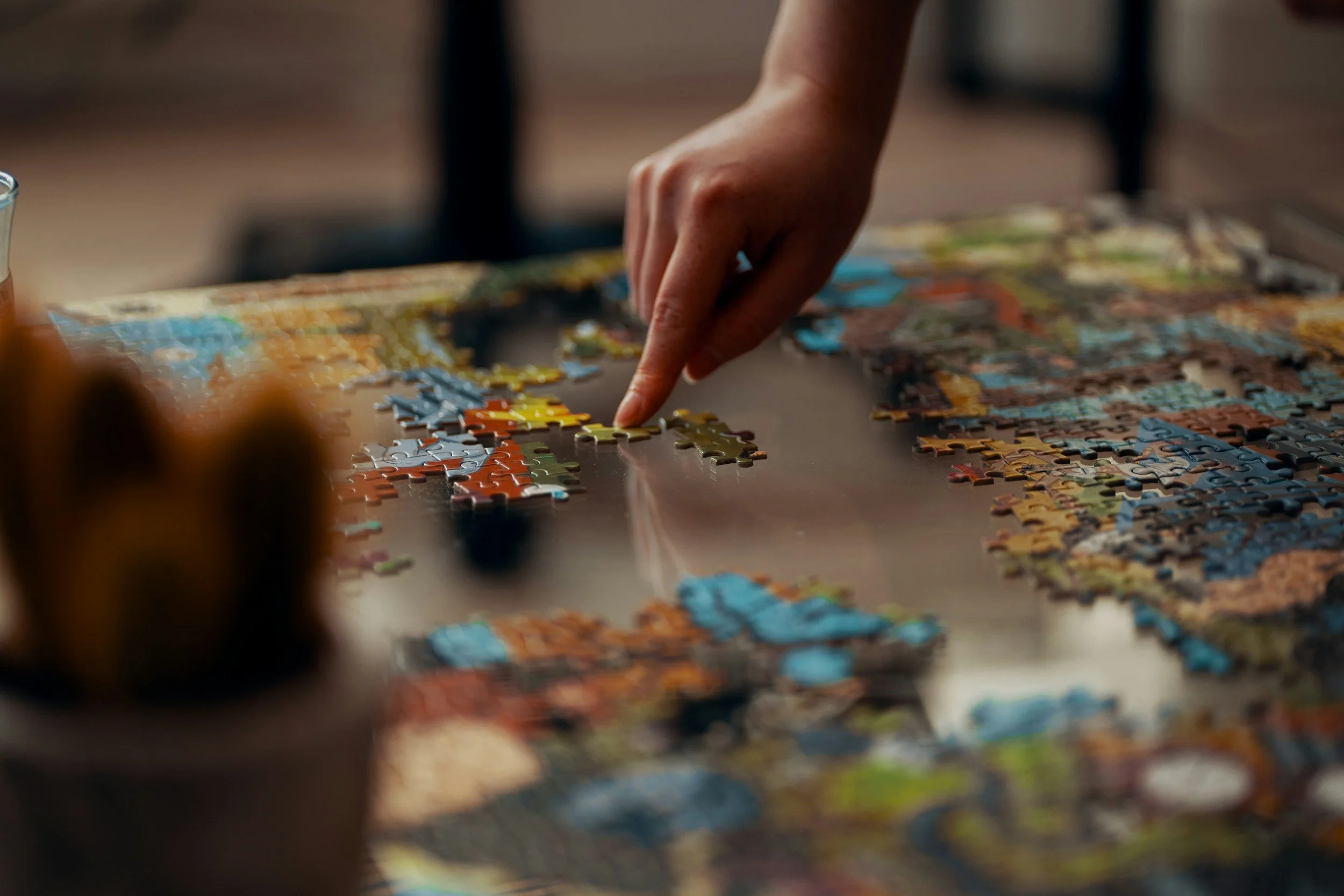 Hands arranging a jigsaw puzzle, symbolizing change management